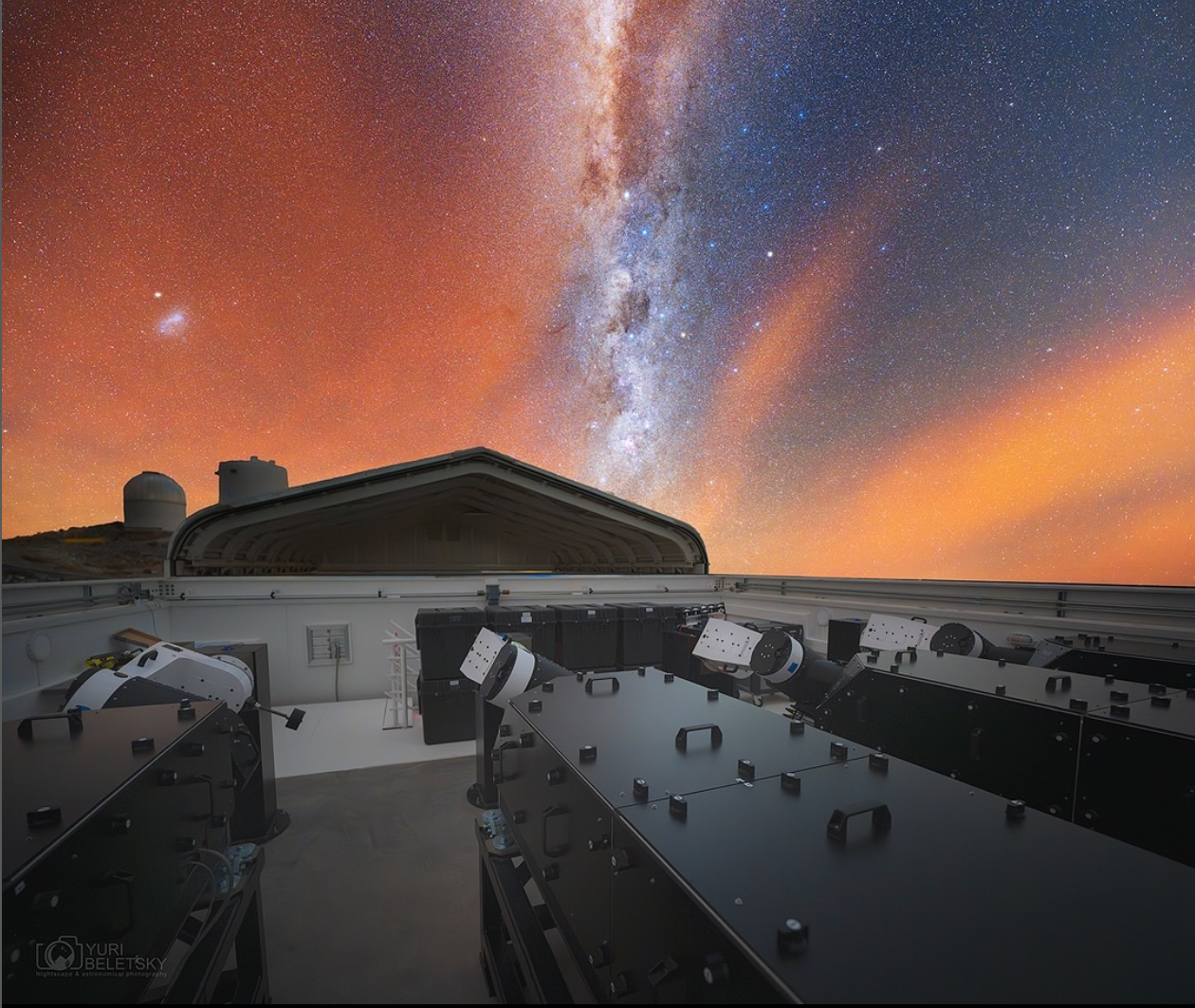 A photo of the four small telescopes that make up the Local Volume Mapper instrument, with the observatory roof open and the Milky Way stretching above