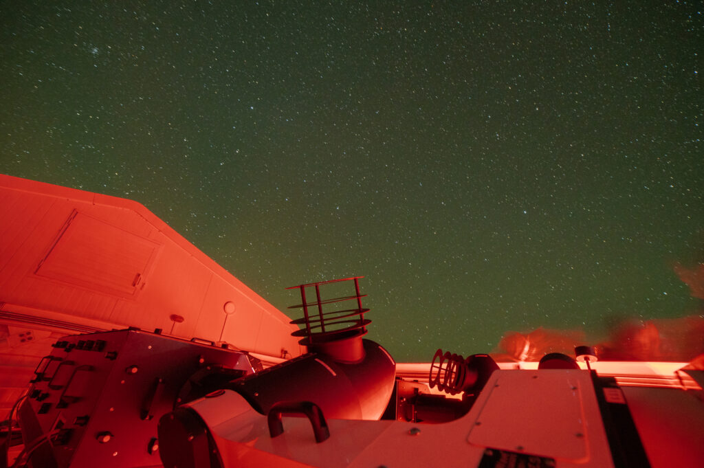 One of the small telescopes that form part of LVM pointing at a starry sky. Another small telescope in the array can be seen behind.