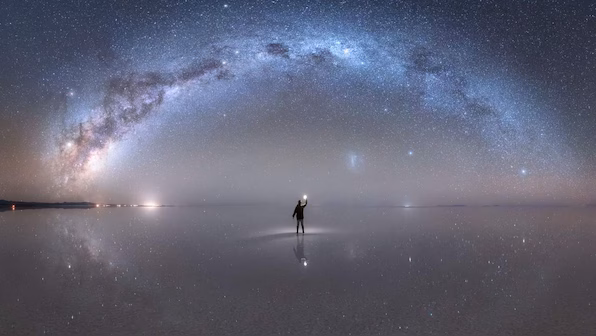 An image of the Milky Way and Magellanic Clouds over a salt flat in Brazil